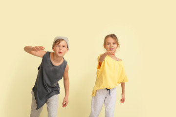 Cute little children dancing against color wall