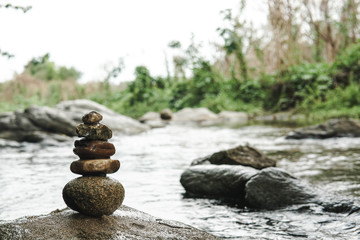 Pebble tower of stones on a river  background. close-up. Summer relax and meditation concept.