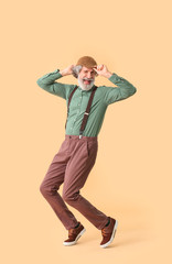 Fototapeta premium Cool senior man dancing against color background
