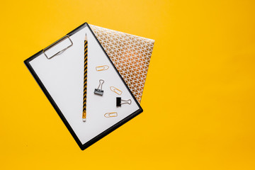 Mockup planner flat lay, top horizontal view yellow background. Notepad and notebooks with stationery. Golden, white and black colors. Back to school, education concept.
