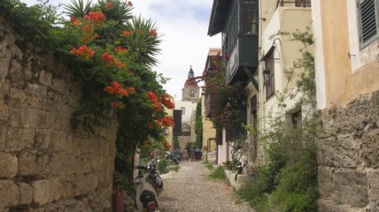 View of the clock tower at the end of a narrow alley
