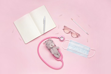 Stethoscope, stationery, medical mask and toy on color background