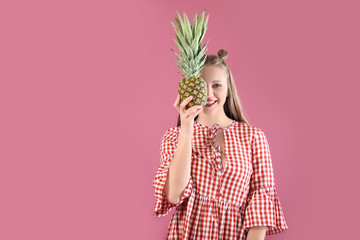 Young woman with pineapple on color background. Diet concept