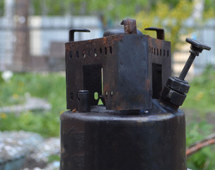 
old gas burner stands on a background of beautiful nature