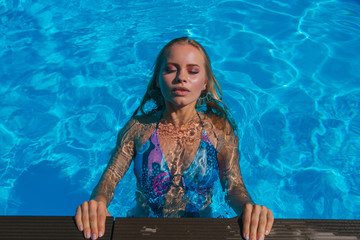 Fashion portrait of beautiful sexy young woman in swimming pool
