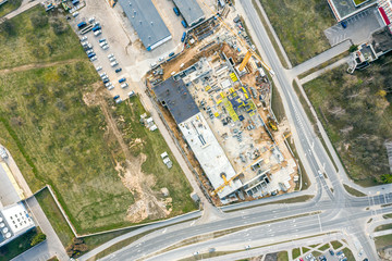 aerial view of new apartment building under construction with working cranes. construction background