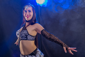 Belly dancer. Young attractive woman dancing tribal fusion on the stage. Oriental exotic dance.