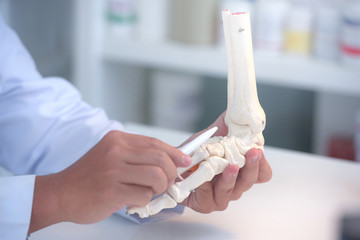 Orthopedic doctor in his office with the patient and the foot model orthopedic doctor in his office...