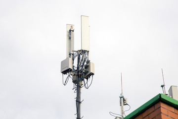 Fototapeta na wymiar Telecommunication tower of 4G andcellular tower of 5G on the roof of a residential building. Radio tower with 5G network.