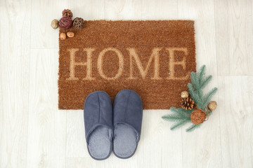 Door mat, Christmas decor and slippers on floor