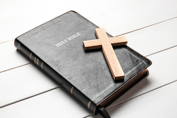 Holy Bible and cross on white wooden background