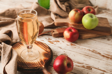 Glass of fresh apple cider on table