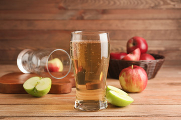 Glass of fresh apple cider on table