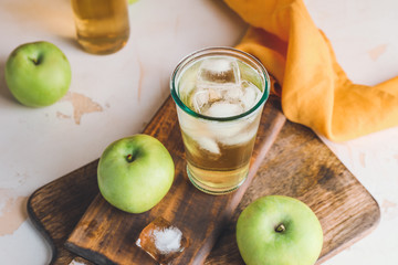 Glass of cold apple cider on table