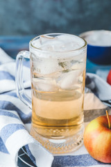 Mug of cold apple cider on table