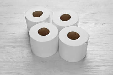 Rolls of toilet paper on white wooden background