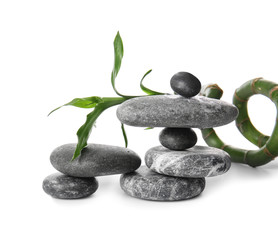 Stack of zen stones and bamboo on white background