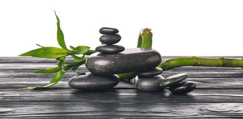 Zen stones and bamboo on table against white background