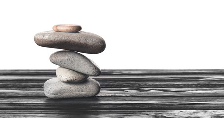 Zen stones on table against white background