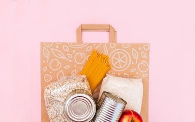 Food for quarantine isolation period flat lay on yellow background with copy space. Eggs, pasta, beans, toilet paper, apple and some seleals. Crisis food supplies.