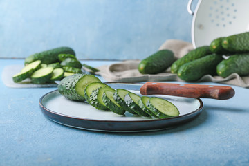Plate with fresh cut cucumber on table