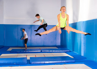 Female gymnast practicing middle split on trampoline