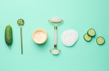 Composition with cucumber and cosmetics on color background