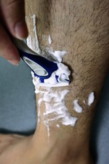 足のムダ毛を剃る男性のクローズアップ