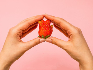 Ugly food: unusual strawberry in a woman hands