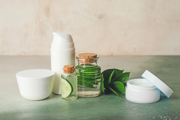 Cosmetics with cucumber extract on table