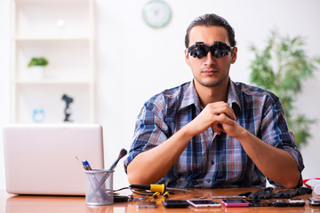 Young male technician repairing mobile phone