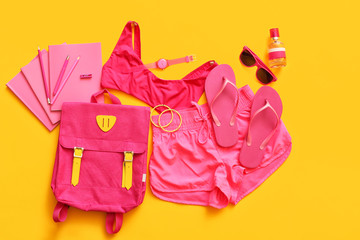 Female accessories and clothes with stationery on color background
