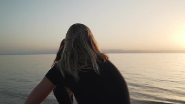 Two girl in black suit practice ecstatic dance at seashore in sunshine
