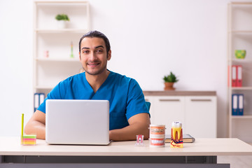 Young male dentist working in the clinic