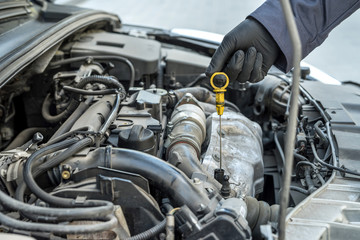 Fototapeta premium mechanic after change of oil in the engine checks level and quality on a probe.