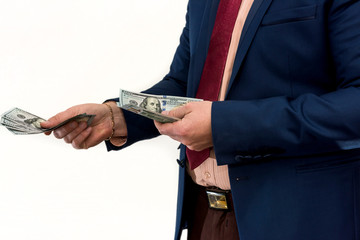 A man in a suit offers a bribe for a product or service. Businessman holds and gives dollars....