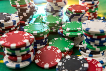 Casino gambling chips on green table. All for game.