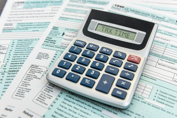 Time for tax, federal form with pen and calculator, office desk