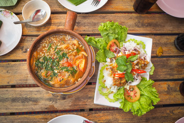 Table of Thai dishes such as curry, eggs, steamed squid, lemon.