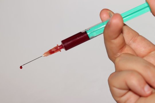 Hand-held syringe with needle with isolated white background