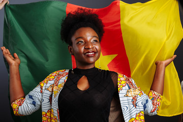 Young beautiful African fashion model with flag of Cameroon in traditional dress.