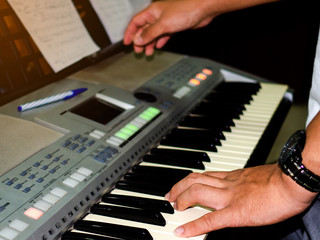Fototapeta na wymiar Picture of young man hand playing the electric piano