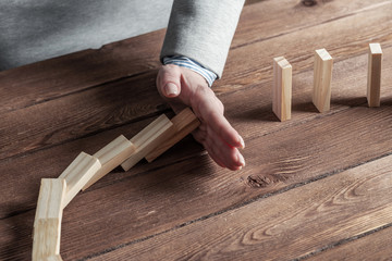Business woman hand stop domino effect