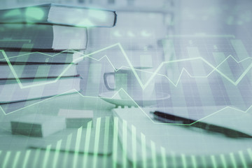 Double exposure of financial chart drawing and desktop with coffee and items on table background. Concept of forex market trading