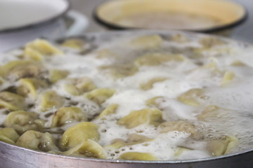 Meat dumplings are boiled in a pan