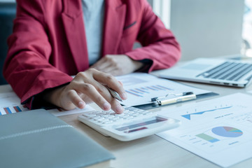 business man is sitting at a desk and calculating financial graph that show results