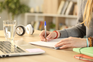 Student hands writing on notebook doing homework