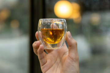 Hand holding a glass with golden water