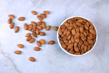 Almonds on a white wooden floor are perfect for a bright and beautiful breakfast.