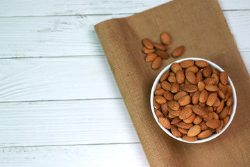 Almonds on a white wooden floor are perfect for a bright and beautiful breakfast.